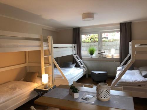 a room with two bunk beds and a desk with a table sidx sidx at Aparthotel Stibbe in Horn-Bad Meinberg