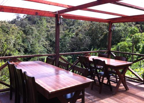 two wooden tables and chairs on a deck at Mile 36 Lodge in Kampong Kundassan