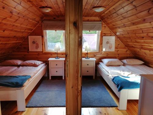 sypialnia z 2 łóżkami w drewnianym domku w obiekcie Na Soltyskiej w mieście Mrągowo