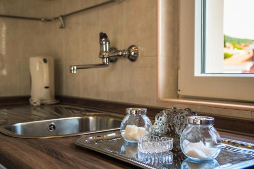 a kitchen sink with two glass jars with eggs in them at Anikol Apartments in Selce