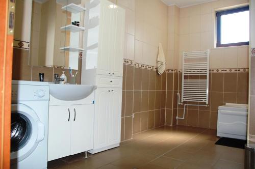 a bathroom with a sink and a washing machine at Apartament Mamaia in Mamaia