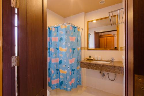 a bathroom with a shower with a sink and a mirror at Khaolak Mohin Tara Resort - SHA Certified in Khao Lak