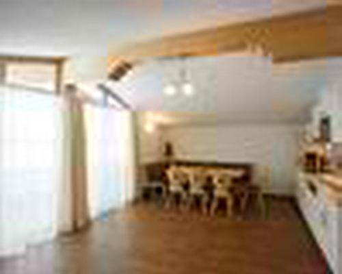 a living room with a table and a fireplace at Landhaus Tirol in Zellberg