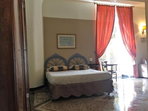 um quarto com uma cama com cortinas vermelhas e uma janela em Casa Brigida em Gênova