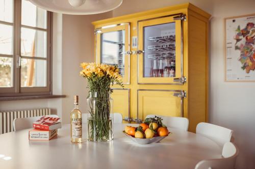 a table with a vase of flowers and a bowl of fruit at Scarpa Villas - Barolo Luxury Escape in Verduno
