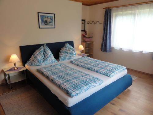 a bedroom with a bed with blue sheets and pillows at Apartment Ossiachersee Treffen in Afritz