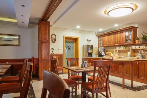 a kitchen and dining room with wooden tables and chairs at Gold House Pension in Balatonfüred