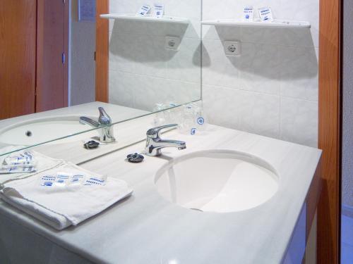 Magic Villa de Benidorm في بنيدورم: حمام أبيض مع حوض ومرآة