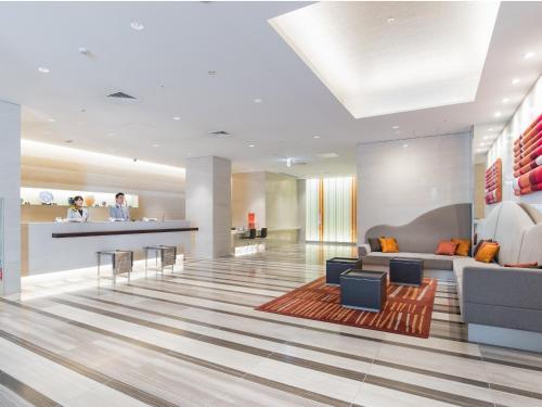 a lobby of a hotel with a couch and a table at JR Kyushu Hotel Blossom Hakata Central in Fukuoka