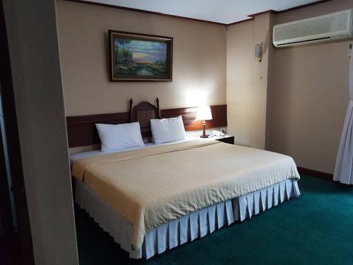 Un pat sau paturi într-o cameră la BaanBusarin Hotel