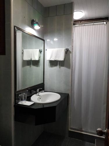a bathroom with a sink and a shower with a mirror at BaanBusarin Hotel in Hua Hin