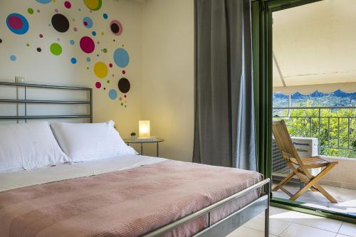 ein Schlafzimmer mit einem Bett, einem Stuhl und einem Fenster in der Unterkunft Sea Apartment in Kateliós
