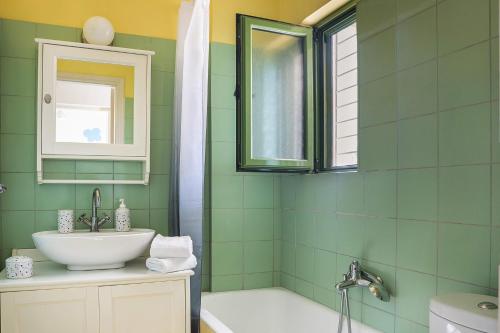 a green bathroom with a sink and a bath tub at Sea Apartment in Katelios