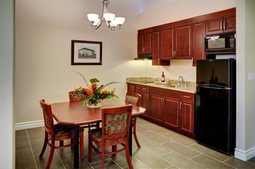a kitchen with a table and a black refrigerator at Chateau Nova Yellowhead in Edmonton