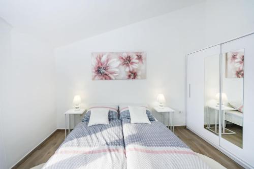 um quarto branco com uma cama e duas mesas em Apartmani NEVA, Pridraga em Pridraga