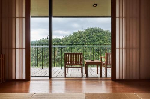 an open door with a table and chairs on a balcony at Hotel Royal Chiao Hsi in Jiaoxi