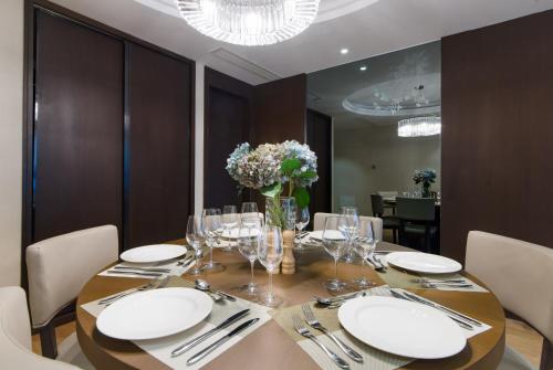 a dining room table with white plates and a vase of flowers at Savills Residence Daxin Shenzhen Bay in Shenzhen