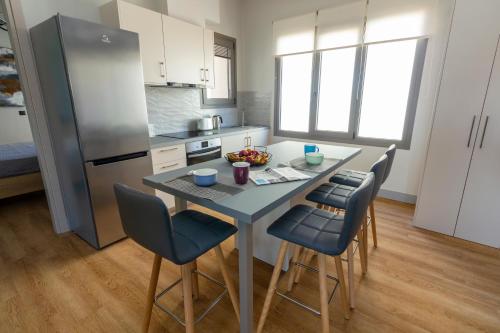 een keuken met een tafel met stoelen en een koelkast bij Heraklion chic and minimalistic apartment with sea view in Heraklion
