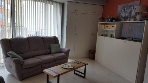 a living room with a couch and a coffee table at Studio Raversijde with Sea View in Ostend