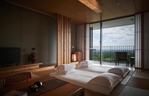 a bedroom with a large bed and a large window at Hotel Royal Chiao Hsi in Jiaoxi