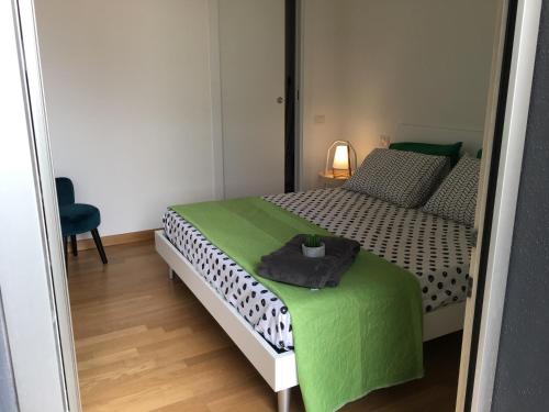 a small bedroom with a bed with a green blanket at H1 bzerohome in Elmas