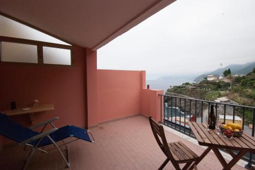 a balcony with a table and chairs and a view of the ocean at Cà de Lelio in Manarola