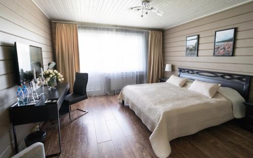 una camera con letto, scrivania e finestra di Zagorodniy Club West a Pribylovo