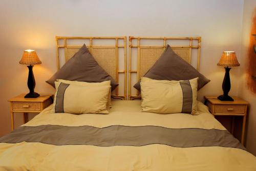a bed with two lamps and two pillows on it at Mahikeng Lodge in Magaliesburg