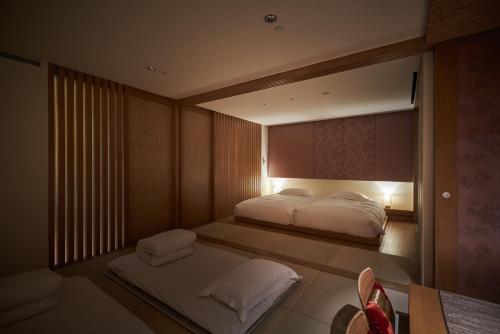 a bedroom with two beds and a large mirror at Hotel Royal Chiao Hsi in Jiaoxi