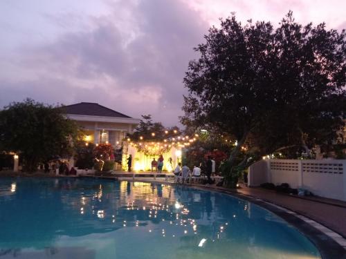 a swimming pool in front of a house at night at Sevilla Resort Magelang in Magelang