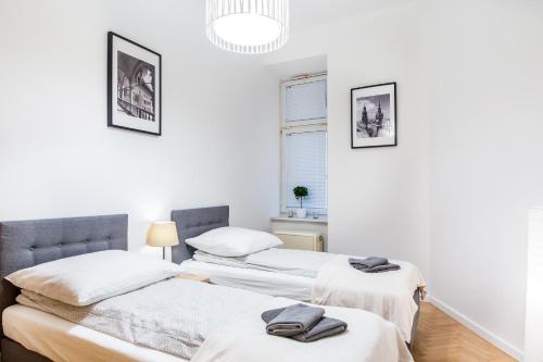 two beds in a room with white walls at Apartament Na Groblach in Kraków