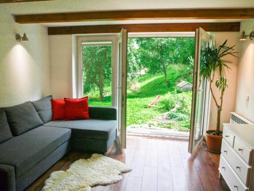 a living room with a couch and a sliding glass door at Pod Klonem in Szczawnica