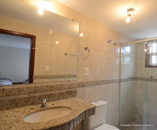 a bathroom with a sink and a mirror and a toilet at Pousada dos Bandeirantes in Ouro Preto