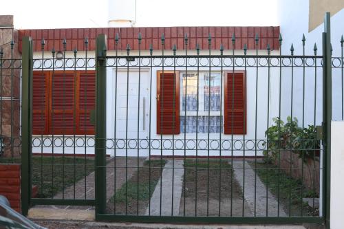 una puerta con persianas rojas en un edificio blanco en Casa Alberdi en Córdoba