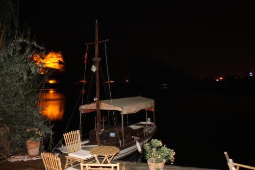 a boat sitting on the water at night at Hotel Happy Caretta in Dalyan