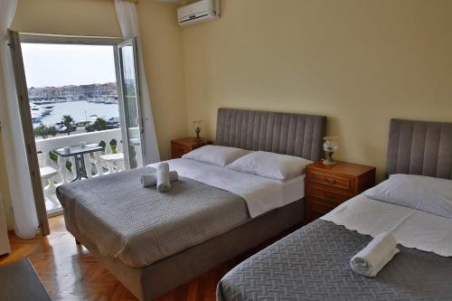 a bedroom with two beds and a balcony with a view at Apartment and Rooms Villa Kolonada in Vodice