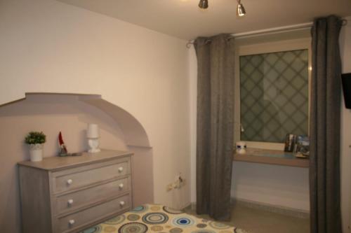 sypialnia z komodą i oknem w obiekcie Delby's house w mieście Neapol