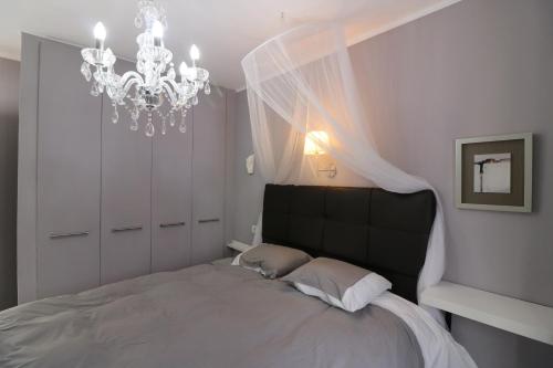 1 dormitorio con 1 cama grande y lámpara de araña en Atlantic Ocean View, en Puerto del Carmen
