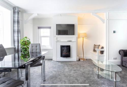 a living room with a fireplace and a tv at Ammonite Luxury beachfront apartment in Lyme Regis