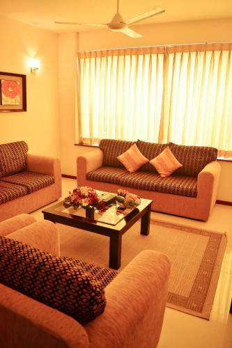 a living room with two couches and a coffee table at Unique Towers Luxury Boutique Suites in Colombo
