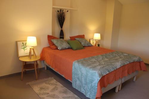 een slaapkamer met een groot bed met 2 lampen bij la verdale in Séguret