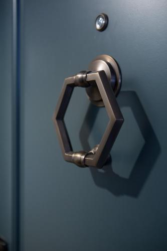 a bronze door handle on a blue door at Hotel Theodore in Seattle