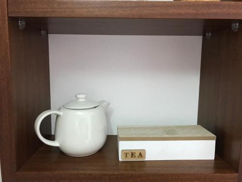 a tea kettle and a box on a shelf at Slow house d'encosta in São Brás de Alportel