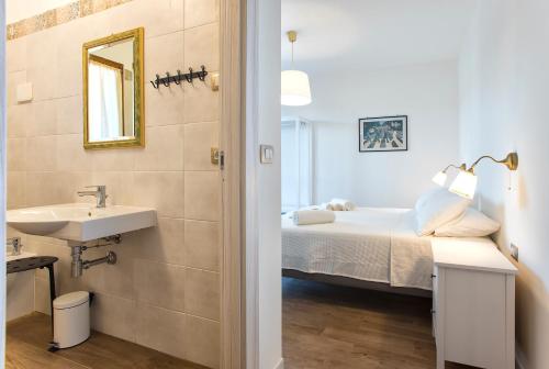 a bathroom with a sink and a bed in a room at Sand'Ana House B&b in Alghero