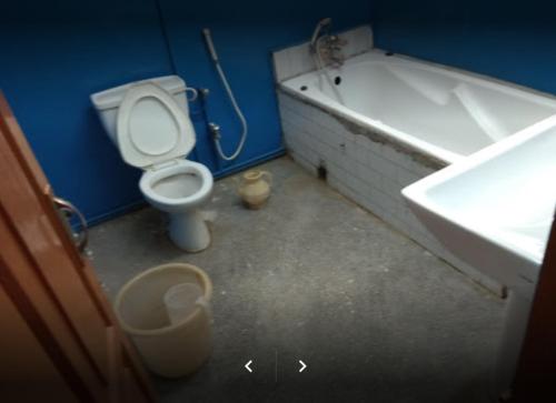 łazienka z toaletą, umywalką i wanną w obiekcie Lourdes Hotel w Kwecie