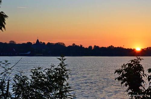 a sunset over a large body of water at Vila Eden Palić in Palić