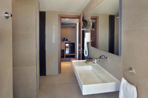 y baño con lavabo blanco y espejo. en Nelia Beach Hotel & Spa, en Ayia Napa