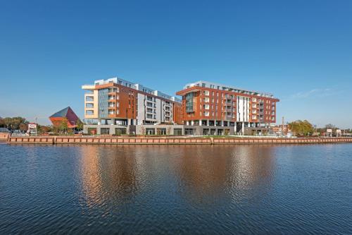 two tall buildings next to a large body of water at Old Town Apartments Apartinfo in Gdańsk