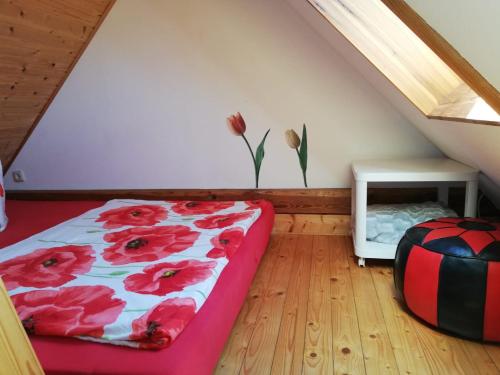 a bedroom with a bed with red flowers on the wall at Ferienwohnungen "Weitblick" und "Schwalbennest" in Lodmannshagen
