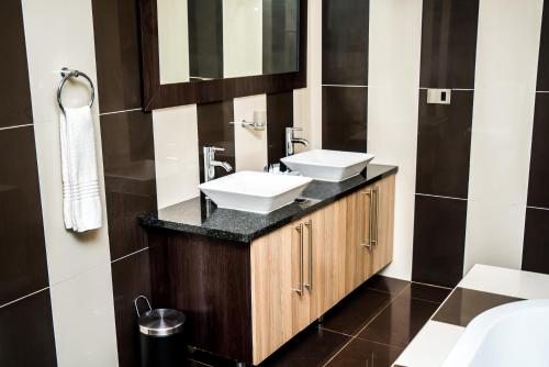 a bathroom with two sinks and a mirror at Ruby Stone Boutique Hotel in Polokwane
